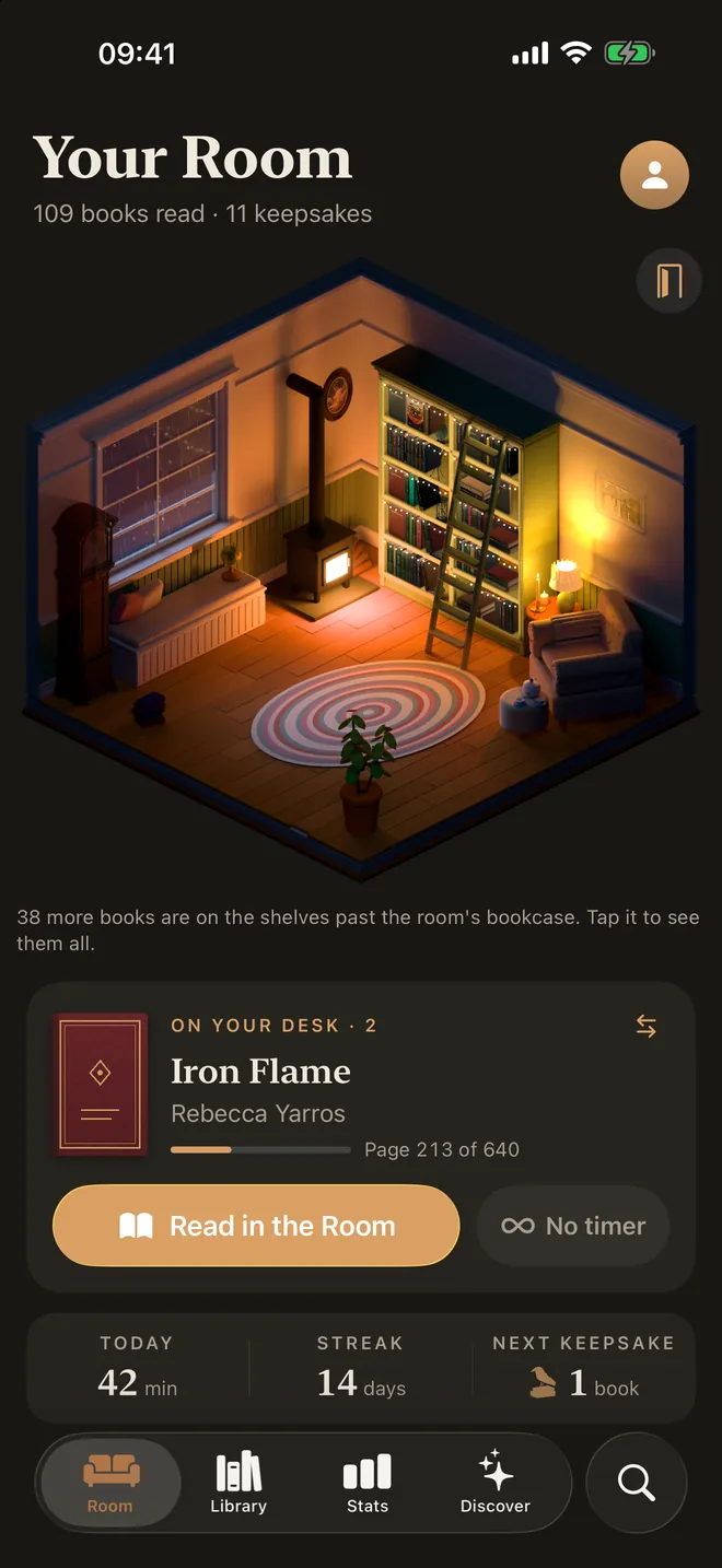 Another Bookling room at night, lit by lamps and a stove.